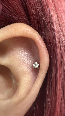 Piercing en el lóbulo con joya floral